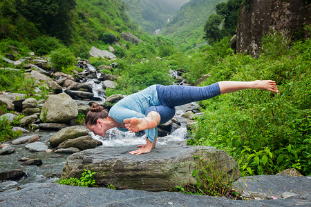 克萨迪亚斯轻的运动健康的妇女瑜伽阿萨纳,埃卡帕达,昆迪尼亚萨纳1热带瀑布热带瀑布瑜伽的女人背景