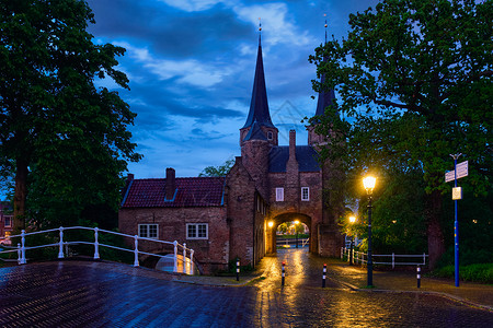 港口东门夜间照明德尔夫特,荷兰晚上德尔夫特的东大门德尔夫特,荷兰图片