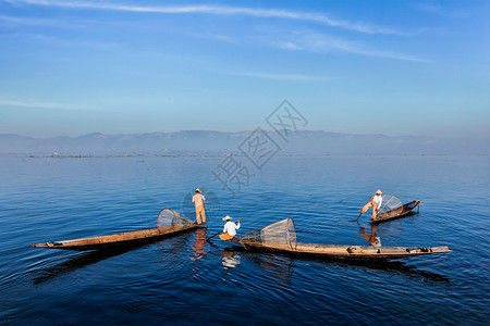 缅甸旅游景点地标传统的缅甸渔民缅甸的inle湖上用渔网捕鱼,以其独特的单腿划船风格而闻名缅甸inle湖的传统缅甸渔民背景图片