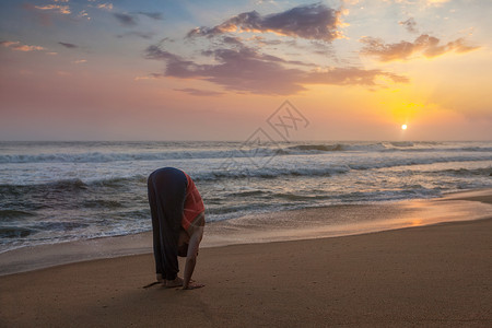 布鲁哈斯轻运动健康的男人瑜伽太阳敬礼苏里亚纳马斯卡姿势哈斯塔乌塔纳萨纳热带海滩日落镜头耀斑轻的运动健康的女人瑜伽背景