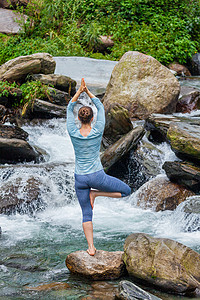 河阿弗里克女人哈塔瑜伽平衡瑜伽,阿莎娜,vrikshasana树姿势瀑布户外瑜伽中的女人瀑布户外摆姿势背景