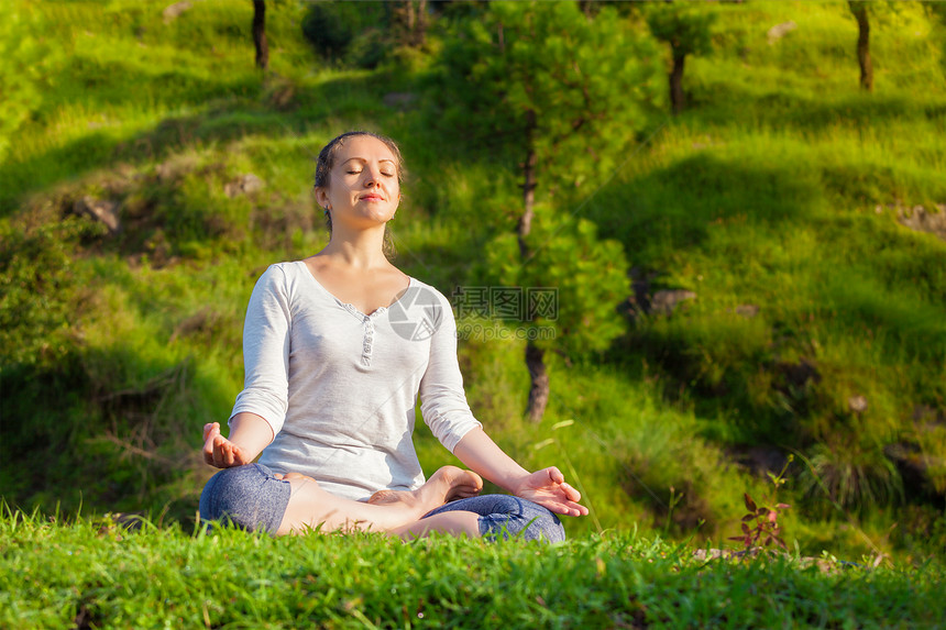 轻运动健康的女人户外瑜伽冥想放松帕德马萨纳莲花姿势与下巴泥德拉绿色的草地森林轻的运动健康的女人瑜伽莲花摆图片