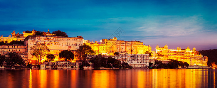 暮光鲁克伦科复古效果过滤了流行风格的全景图片,著名的浪漫豪华拉贾斯坦邦印度旅游地标乌普尔城市宫殿晚上全景乌达普尔,印度乌迪普尔背景