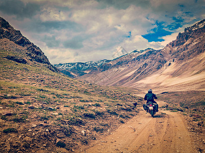 印度复古摩托车复古效果过滤了喜马拉雅山山路上摩托车自行车的时髦风格形象印度希马查尔邦的斯皮蒂山谷喜马拉雅山的山路上骑自行车背景