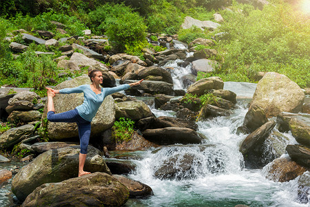 时光流逝如瀑布瑜伽户外妇女瑜伽,如纳塔拉贾萨纳主舞平衡姿势户外瀑布喜马拉雅山瀑布户外瑜伽的女人背景