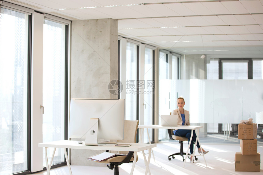 电脑器办公桌上,女商人办公室的后台工作图片