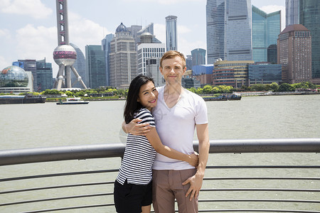 微笑的夫妇站栏杆旁的肖像,背景上海的天际线图片