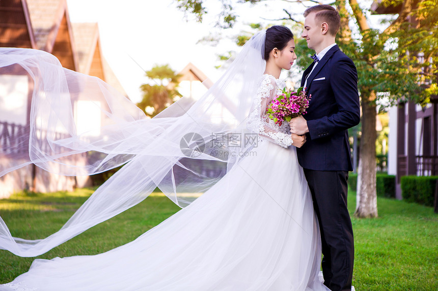 站草坪上的新婚夫妇的侧景图片