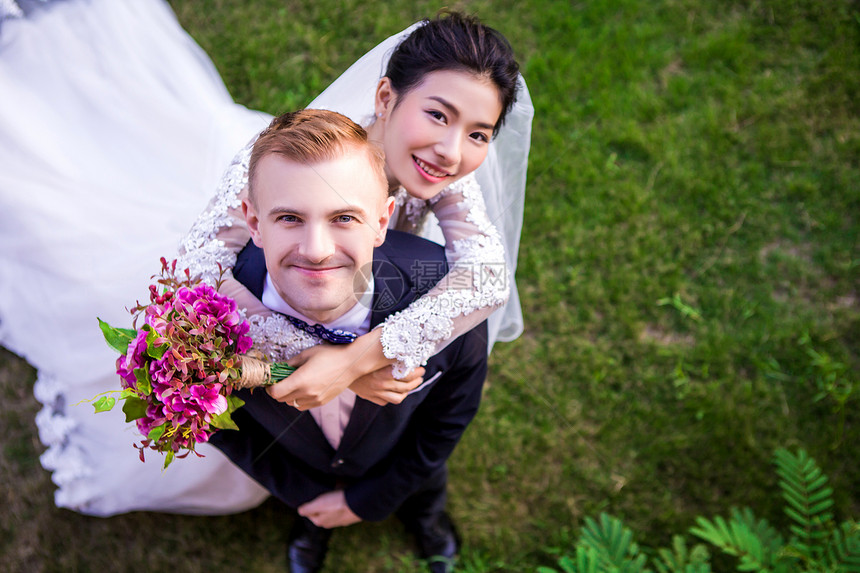 站草地上的幸福新婚夫妇的高角度肖像图片