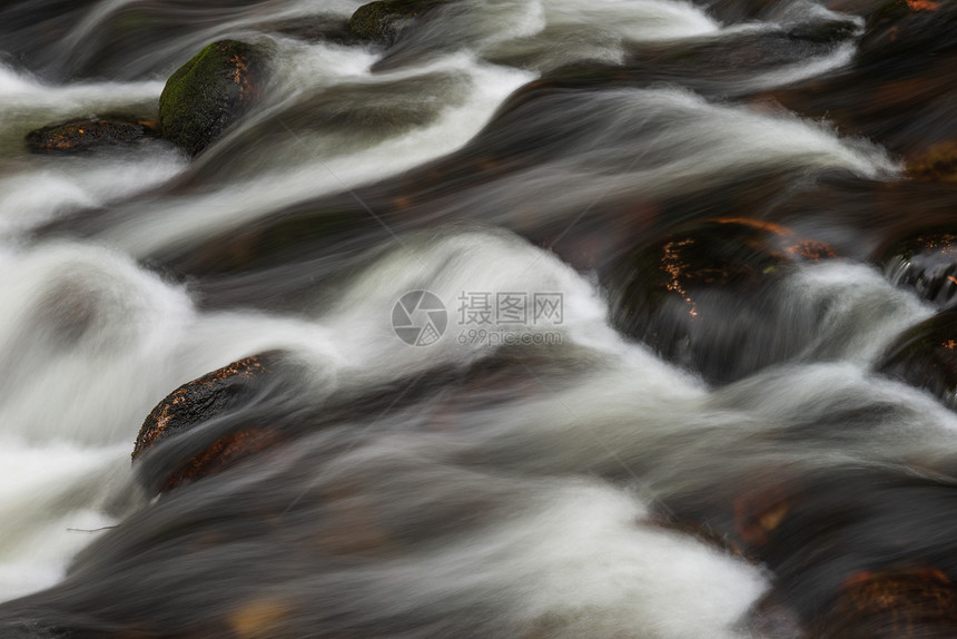 河流流经岩石的详细景观图像,长曝光运动模糊图片