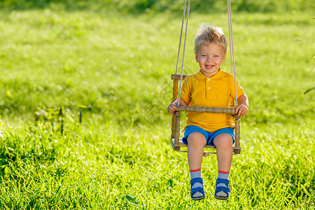 绿色秋千幼儿户外摆动的肖像农村场景与岁的男孩秋千健康的学龄前儿童暑期活动孩子外玩背景