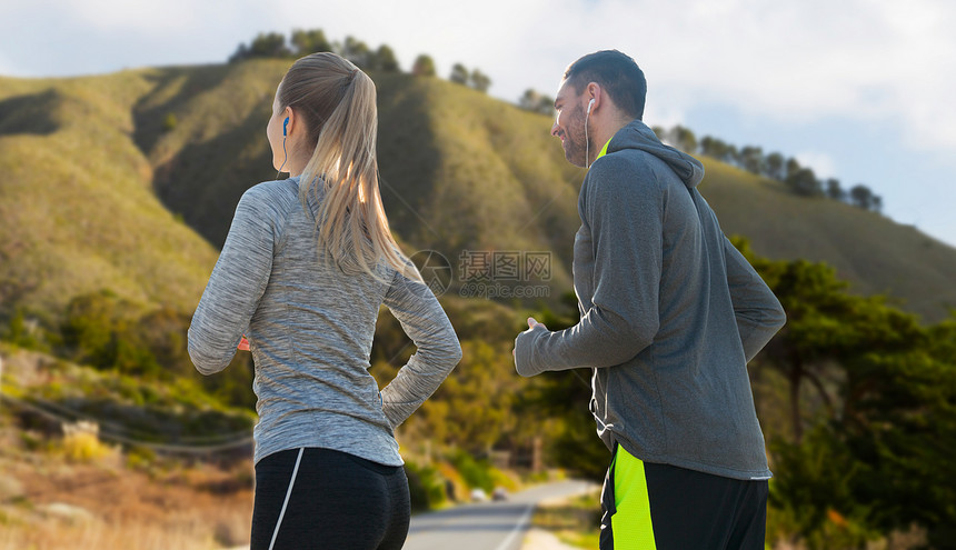 健身,运动技术快乐的夫妇跑步听音乐耳机大苏尔山背景加利福尼亚夫妇带着耳机跑过大苏尔图片