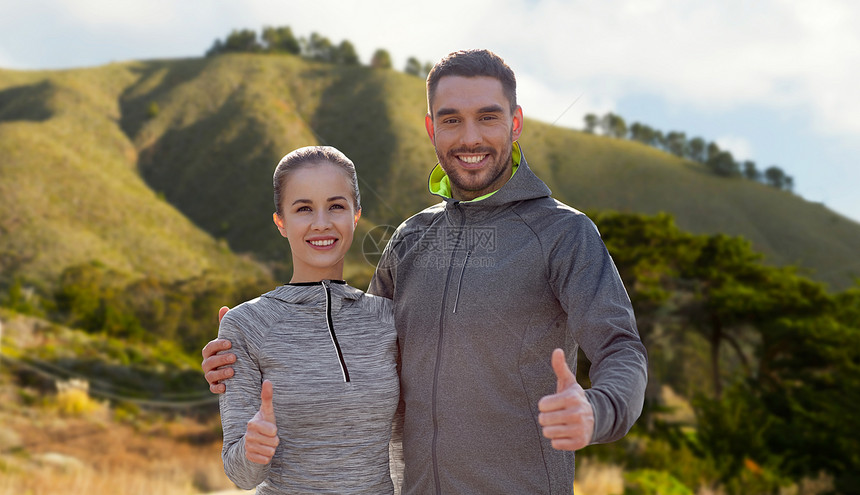 健身,运动手势微笑的夫妇户外拇指大苏尔山背景加利福尼亚穿着运动服的微笑夫妇竖大拇指图片