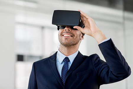 商业,技术增强现实微笑商人与VR耳机办公室办公室配备虚拟现实耳机的商人图片