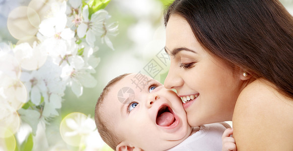 家庭母亲的快乐的微笑轻母亲与小婴儿樱花背景母亲带着孩子樱花背景下图片