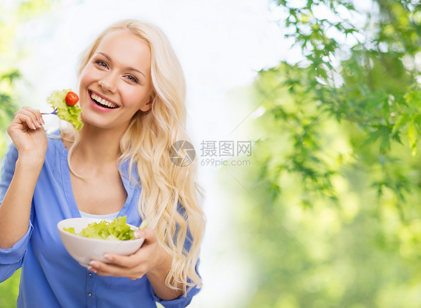 健康的饮食,饮食人的微笑的轻女人与蔬菜沙拉绿色的自然背景微笑的轻女人吃蔬菜沙拉图片