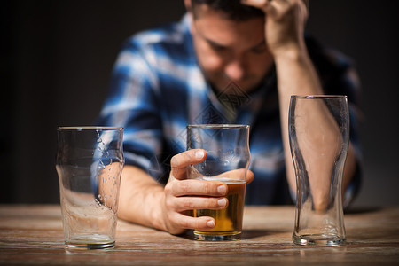 艾尔啤酒酒精中,酒精成瘾人们的男酒精饮料啤酒璃晚上晚上用璃杯喝啤酒背景