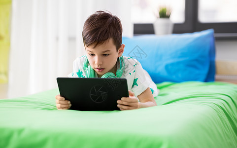 童,技术人的男孩与平板电脑电脑玩游戏家里男孩家里玩平板电脑电脑游戏图片