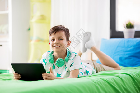 童,技术人的微笑的男孩与平板电脑家里微笑的男孩家里用平板电脑电脑图片
