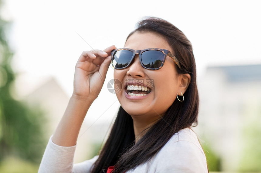 夏天,眼镜人的快乐微笑的轻女人户外太阳镜的肖像户外戴太阳镜的轻女人的肖像图片