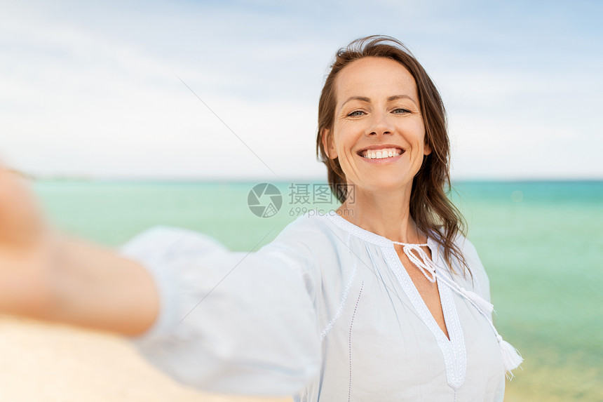暑假休闲快乐的微笑女人海滩上自拍快乐微笑的女人夏天的海滩上自拍图片