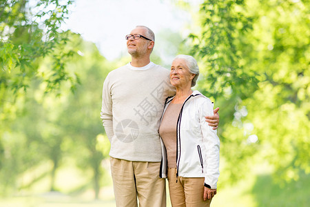 老人的幸福的老夫妇拥抱绿色的自然背景老夫妇拥抱自然背景图片