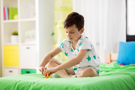 童,想象梦想的快乐的小男孩家里床上玩飞机玩具快乐的小男孩家里玩飞机玩具图片