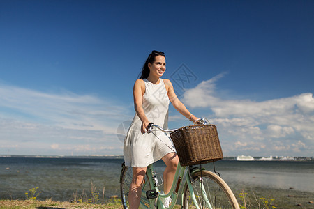 人们,休闲生活方式快乐的轻时髦女人穿着夏天的衣服,海边骑固定自行车快乐的轻女人海滩上骑固定自行车背景图片