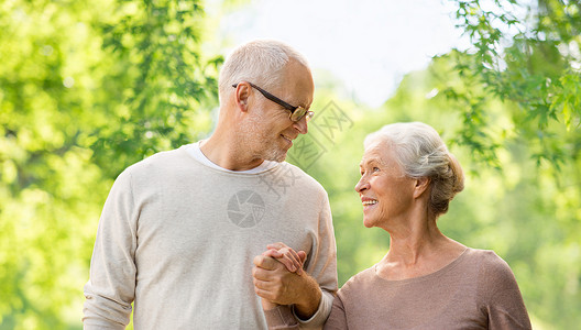 老人的幸福的老夫妇牵手绿色的自然背景幸福的老夫妇着绿色的自然背景图片
