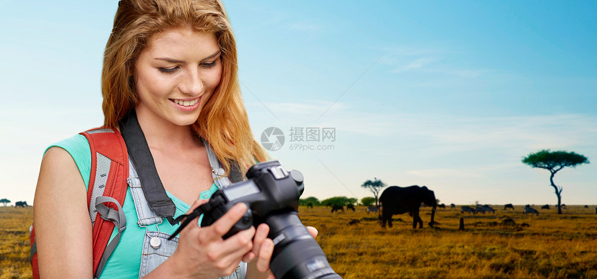 旅行,旅游摄影快乐的轻妇女背包相机拍摄动物非洲草原背景女人带着背包相机萨凡纳上空图片