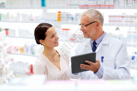 医药,医疗技术高级药剂师女客户与平板电脑电脑药房药剂师客户药房用平板电脑图片