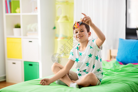 童,想象梦想的快乐的小男孩家里床上玩飞机玩具快乐的小男孩家里玩飞机玩具图片
