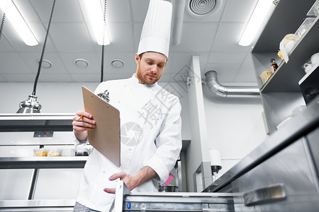 烹饪,职业人的男厨师与剪贴板库存寻找冰箱餐厅厨房厨师带着剪贴板厨房存货图片