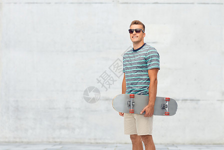 运动,休闲滑板微笑的轻人与滑板混凝土墙壁背景微笑的轻人,滑板超过白色图片