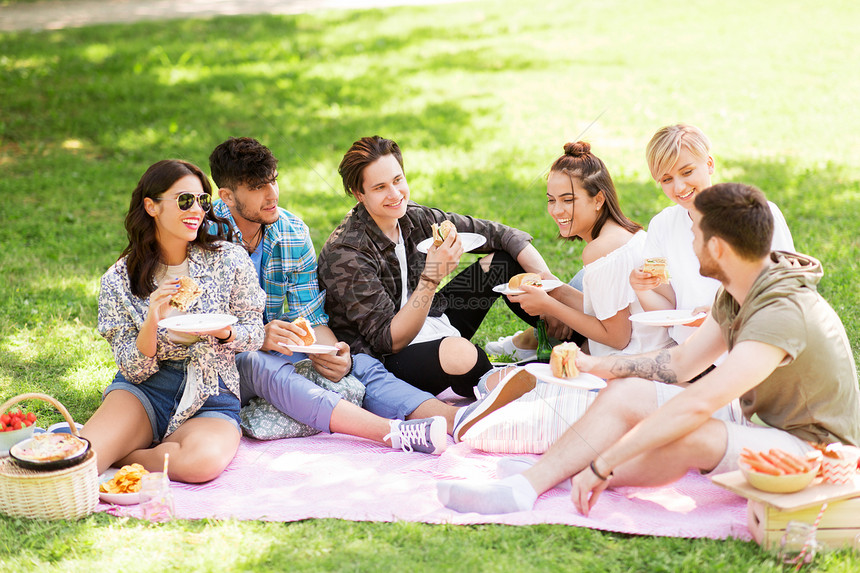 友谊休闲快餐群快乐的朋友夏天公园野餐时吃三明治汉堡快乐的朋友夏天野餐时吃三明治图片