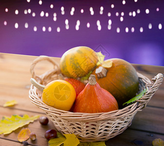 葫芦与叶子万节,收获秋天的南瓜柳条篮子与叶子木制桌子上的紫外线背景把南瓜放木桌上的篮子里背景