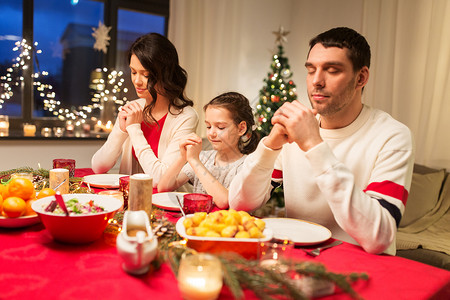 节日,家庭庆祝快乐的母亲,父亲小女儿家里吃诞晚餐饭前祈祷家人诞晚餐前祈祷图片