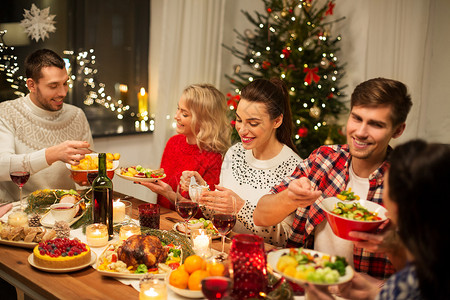 节日庆祝快乐的朋友家里吃诞晚餐吃食物快乐的朋友家吃诞晚餐背景图片