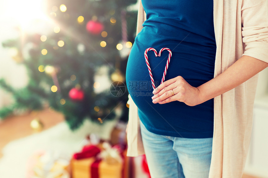 怀孕,诞节人们的密切孕妇的心脏由糖果罐头肚子家里诞节把孕妇抱得很紧图片