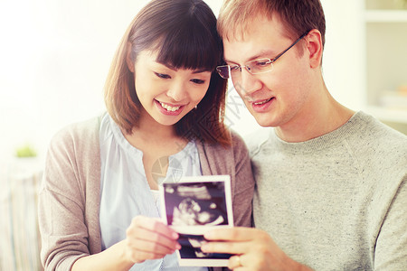 怀孕,家庭人的亲密的幸福夫妇家里看婴儿超声图像用婴儿超声幸福的夫妇图片