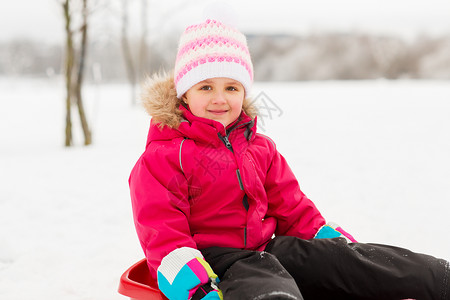 童,雪橇季节快乐的小女孩坐雪橇户外冬天冬天户外雪橇上快乐的小女孩图片