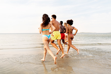 友谊,暑假人们的快乐的朋友海滩上跑步快乐的朋友夏天的海滩上跑步图片