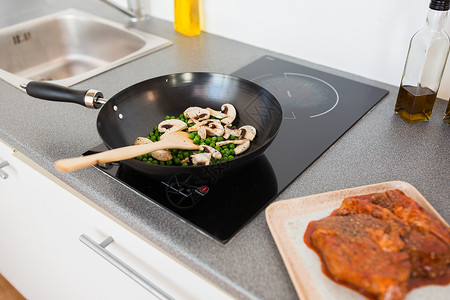 食物,烹饪烹饪蘑菇与豌豆煎锅上的炊具烹饪板上煎锅中的食物背景图片