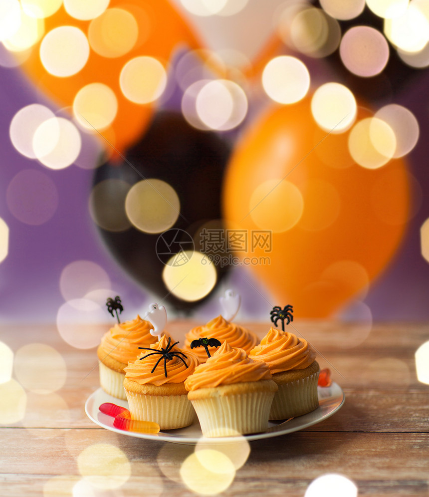 食物,烘焙假日纸杯蛋糕松饼与万节派装饰糖果盘子上的灯光万节派装饰的纸杯蛋糕盘子里图片