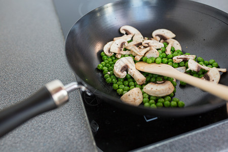 食物,烹饪烹饪蘑菇与豌豆煎锅上的炊具烹饪板上煎锅中的食物图片