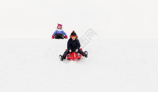 骑着摩托男孩童,雪橇季节快乐的孩子们冬天乘雪橇滑下雪山快乐的孩子们冬天乘雪橇下山背景