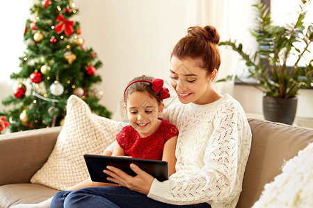 诞节,技术家庭快乐的母亲小女儿家里用平板电脑电脑诞节平板电脑的母女图片