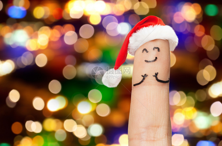诞节,假日身体部分的手指诞帽节日灯背景灯光下,诞老人的帽子里闭上手指图片