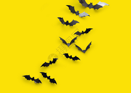 纸蝙蝠万节装饰品许多黑色纸蝠黄色背景黄色背景的黑色万节蝙蝠背景