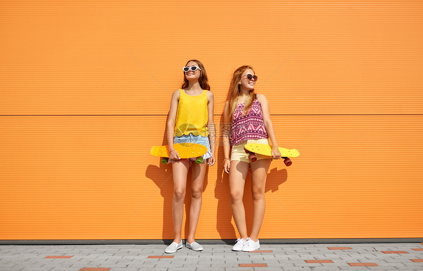 友谊,休闲人的快乐的十几岁的女孩朋友与短滑板城市街道夏天城市里短滑板的十几岁女孩图片